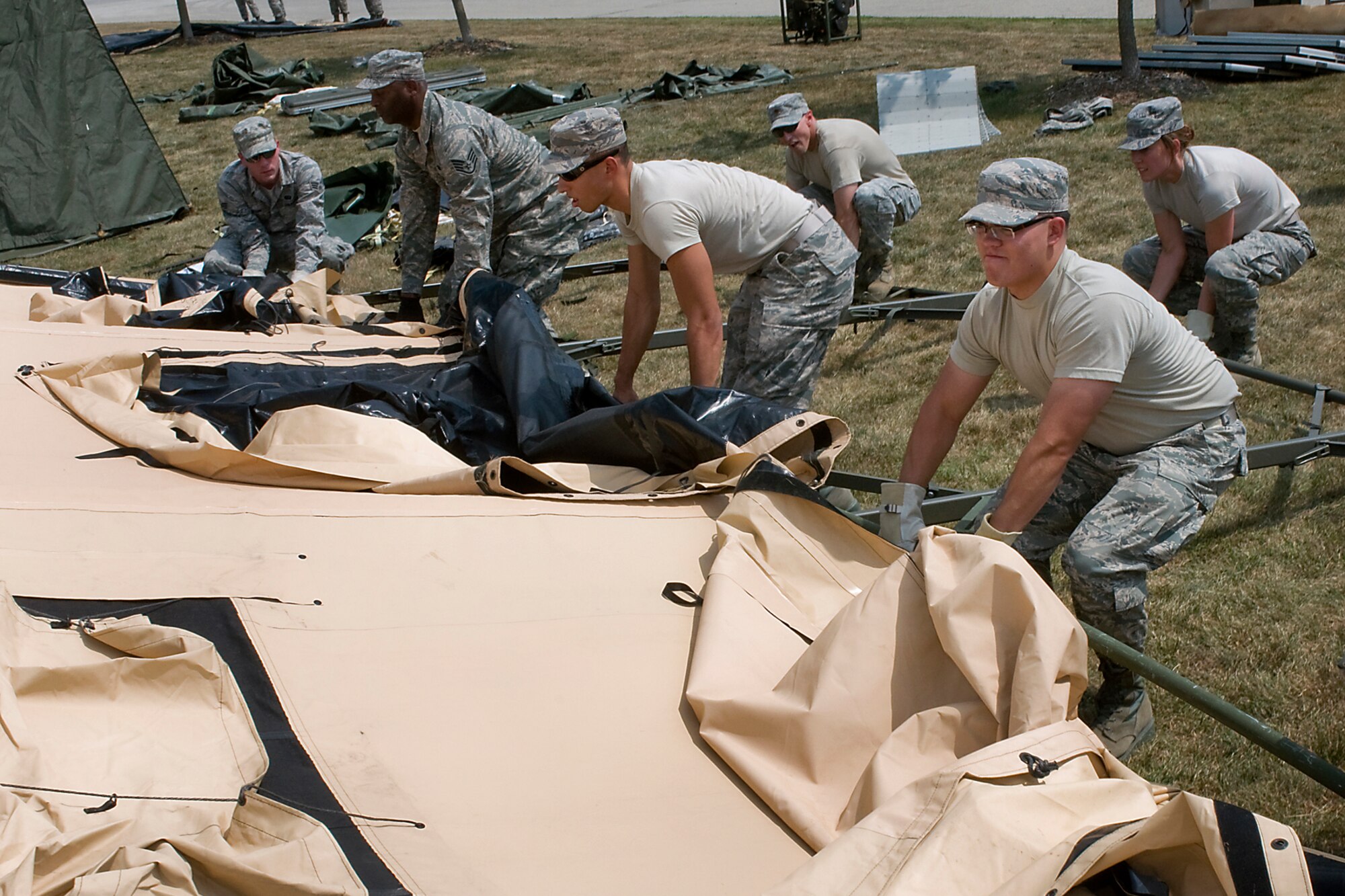 Airmen from the 434th Force Support Squadron lift a tent as they set up a single palletized expeditionary kitchen, or SPEK, as part of their annual field training Aug. 8. The training provided the Airmen with skills useful in a deployed environment. (U.S. Air Force photo/Senior Airman Jami K. Lancette)