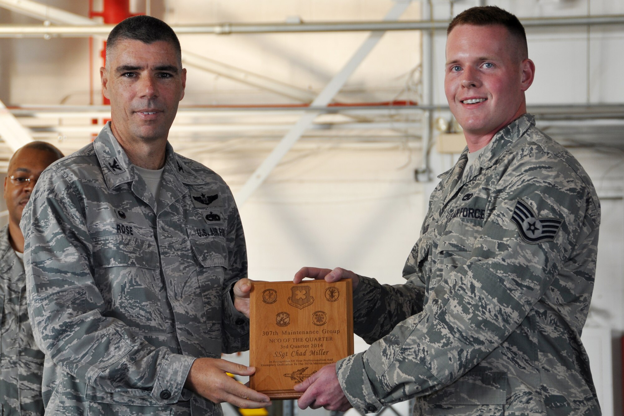U.S. Air Force Col. Kenneth Rose, 307th Maintenance Group commander, presents the Noncommissioned Officer of the Quarter award to Staff Sgt. Chad Miller, Sept. 6, 2014, Barksdale Air Force Base, La. Miller won the award for the 3rd quarter of 2014. (U.S. Air Force photo by Master Sgt. Mary Hinson/Released)