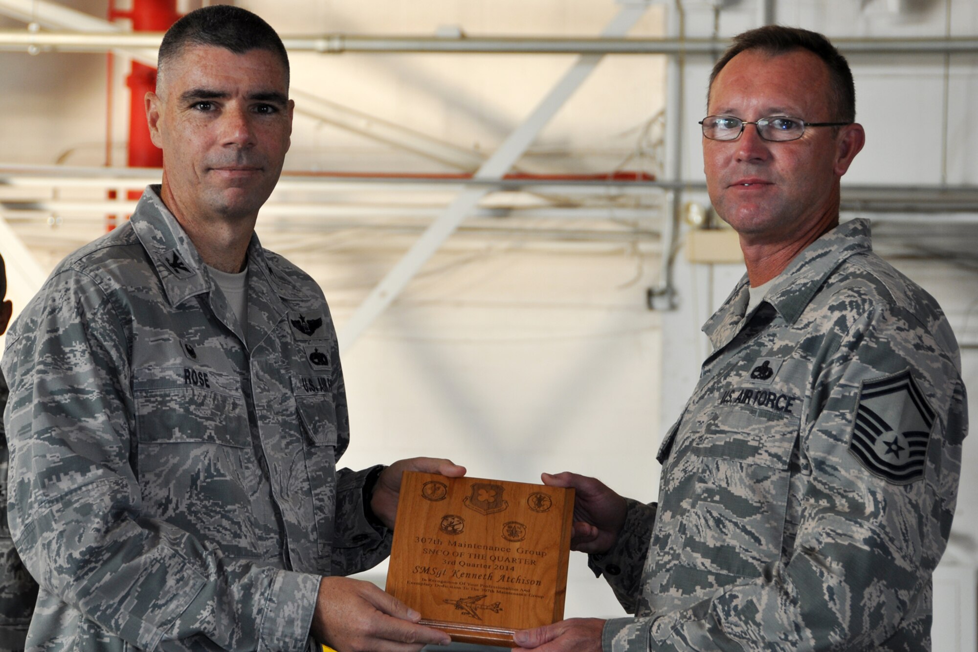 U.S. Air Force Col. Kenneth Rose, 307th Maintenance Group commander, presents the Senior Noncommissioned Officer of the Quarter award to Senior Master Sgt. Kenneth Atchison, Sept. 6, 2014, Barksdale Air Force Base, La. Atchison won the award for the 3rd quarter of 2014. (U.S. Air Force photo by Master Sgt. Mary Hinson/Released)