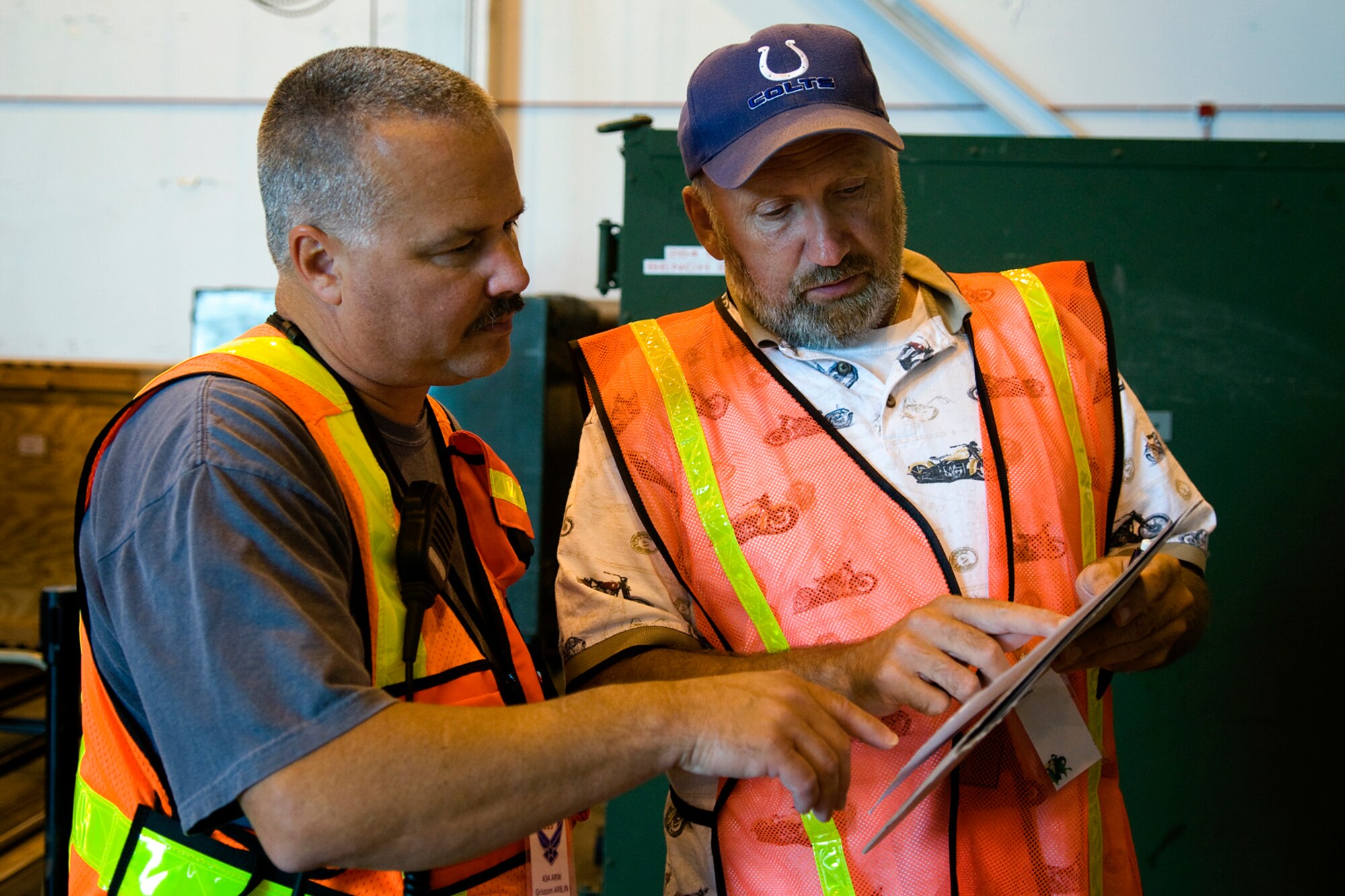 Scott Shives, 434th Communications Squadron information assurance manager, left, and Allen Edgerley, 434th Logistics Readiness Squadron supply and fuels quality assurance evaluator, discuss mobility processing procedures during an exercise here July 12. Both are wing inspection team members. (U.S. Air Force photo/Tech. Sgt. Mark R. W. Orders-Woempner)