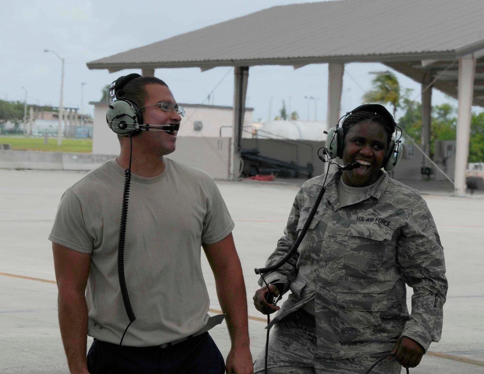 Staff Sgt. Tijuana L. Hamilton, aerospace medical technician for the 482nd Medical Squadron, and Senior Airman Jonathan Escobar, assistant dedicated crew chief from Detachment 93, 495th Fighter Group laugh as they practice hand motions for parking a plane at Homestead Air Reserve Base, Fla., 4 Sept. Hamilton was nominated for the honor of being a crew chief for a day due to her service to the 482nd Maintenance Group in preparation for their recent deployment cycle. (U.S. Air Force photo by Senior Airman Aja Heiden)