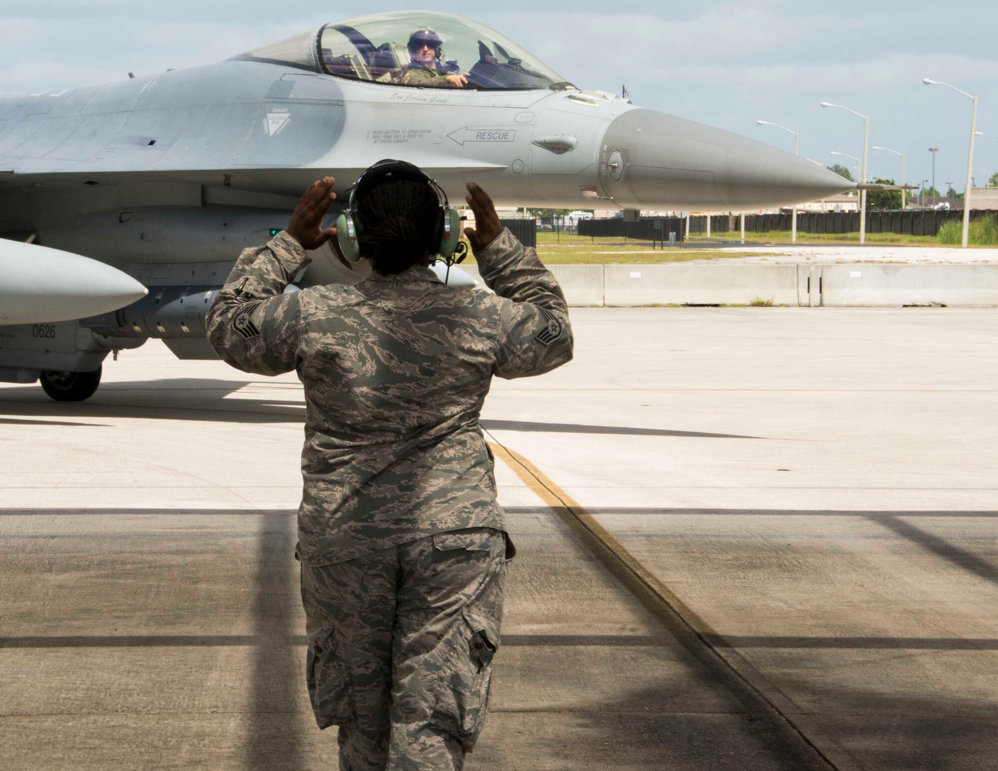 Staff Sgt. Tijuana Hamilton, a medical technician for the 482nd Medical Squadron, marshals an F-16C aircraft into a parking spot at Homestead Air Reserve Base, Fla., 4 Sept. Hamilton was selected to be a crew chief for a day where she partnered with Senior Airman Jonathan Escobar, assistant directed crew chief for Detachment 93, 495th Fighter Group here, to get a firsthand view of life on the flight line. (U.S. Air Force photo by Senior Airman Jaimi L. Upthegrove)