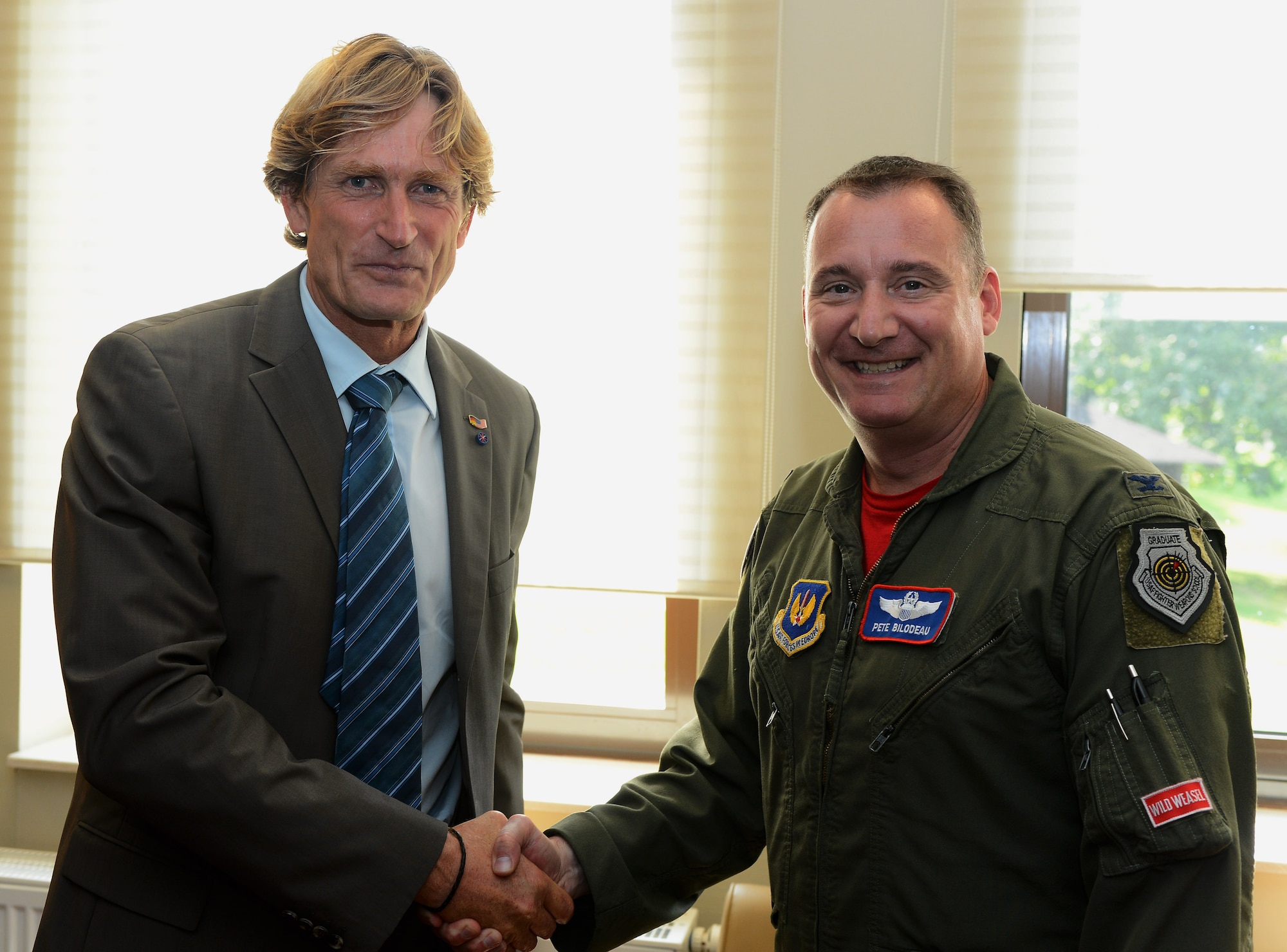 Jan Niewdniczanski, president of the Host Nations Council Spangdahlem e.V., greets U.S. Air Force Col. Pete Bilodeau, 52nd Fighter Wing commander, during the opening of the HNC desk at the Saber Conference Center at Spangdahlem Air Base, Germany, Sept. 5, 2014. The HNC desk will provide Sabers with numerous opportunities to get involved and learn about German culture. (U.S. Air Force photo by Airman 1st Class Luke J. Kitterman/Released)
