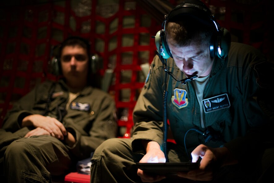 U.S. Air Force Staff Sgt. Brent Slyter, 71st Rescue Squadron loadmaster, looks at a tablet while en route to an aerial refueling mission over Tennessee, Sept. 4, 2014. During aerial missions such as refueling, static-line jumps or cargo drops, loadmasters complete checklists to ensure proper procedure is being followed. (U.S. Air Force photo by Airman 1st Class Ryan Callaghan/Released)