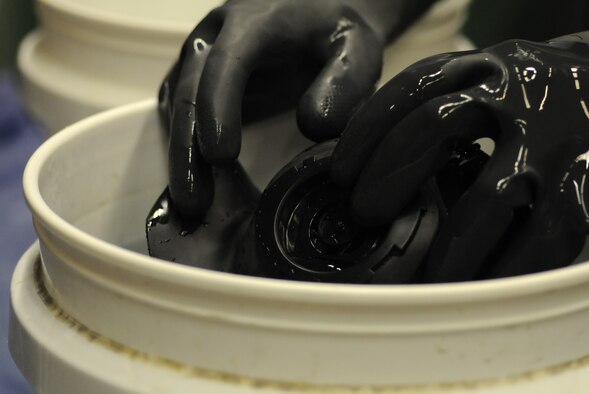 U.S. Air Force Airman 1st Class Myishmial Pearson, 100th Logistics Readiness Squadron Material Management Individual Protective Equipment apprentice from Chicago, sanitizes a M-50 gas mask Sept. 5, 2014, on RAF Mildenhall, England. After cleaning the mask, Pearson assembles it so it’s ready for issue. (U.S. Air Force photo/Gina Randall/Released)