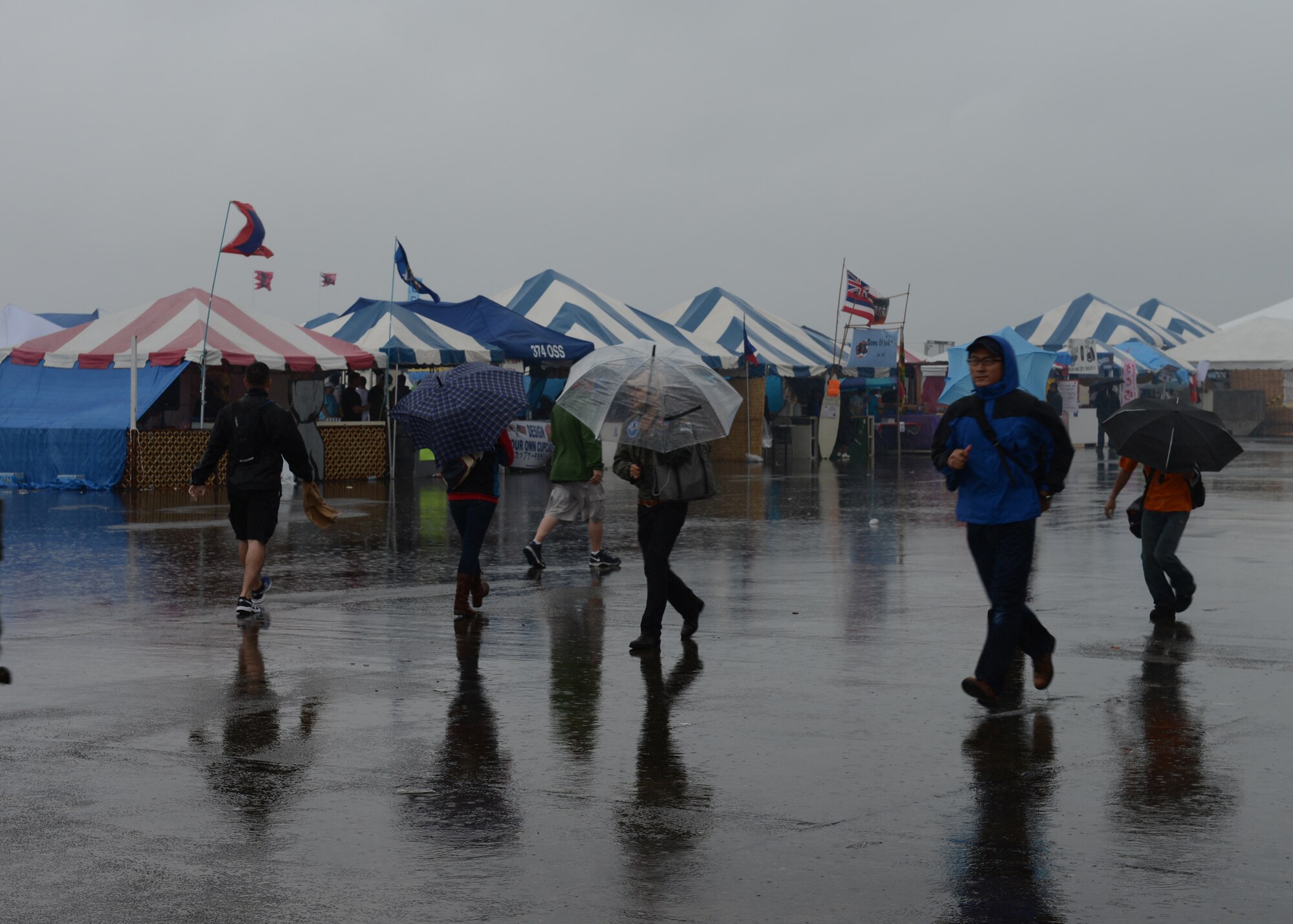 Festival goers attend the Japanese-American Friendship Festival despite the rain at Yokota Air Base, Japan, Sept. 7, 2014. More than 148,000 people attended this year's festival, which featured a variety of U.S. and Japanese military and offered an array of food booths and live entertainment. (U.S. Air Force photo by Airman 1st Class David C. Danford/Released)