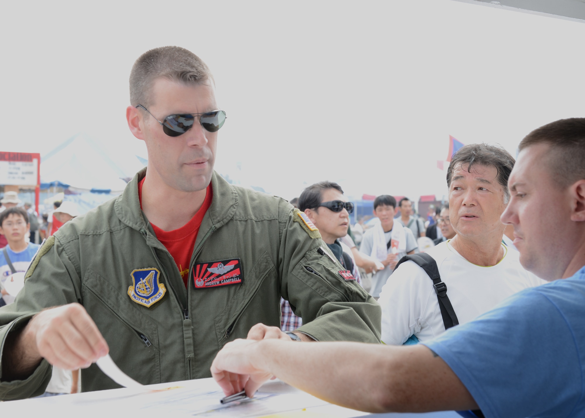 Lt. Col. Andrew Campbell, 36th Airlift Squadron commander, visits the information booth at the Japanese-American Friendship Festival at Yokota Air Base, Japan, Sept. 6, 2014. Orange wristbands were provided to children under six years old to keep them from getting lost during the event. (U.S. Air Force photo by Airman 1st Class David C. Danford/Released)