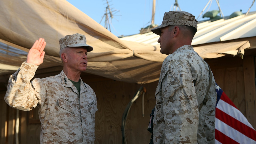 Gen. James F. Amos, the 35th Commandant of the Marine Corps, administers the oath of enlistment to Sgt. Dominic Sharpsteensurina, an assault section leader with Charley Company, 1st Battalion, 7th Marine Regiment, following his meritorious promotion ceremony aboard Camp Leatherneck, Afghanistan, Sept. 6, 2014. Gen. Amos meritoriously promoted Sharpsteensurina, a native of Minneapolis, to the rank of sergeant during his final visit to Helmand province.