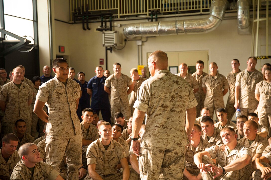 Lance Cpl. Franky Guzman (left) asks Lt. Gen. Robert Neller (center), the commanding general of Marine Corps Forces Command, a question during Neller’s visit to Naval Air Station Sigonella Aug. 9, 2014. Neller visited NASSIG to meet service members with the second iteration of SP-MAGTF Africa 14. (U.S. Marine Corps photo by Cpl. Shawn Valosin)