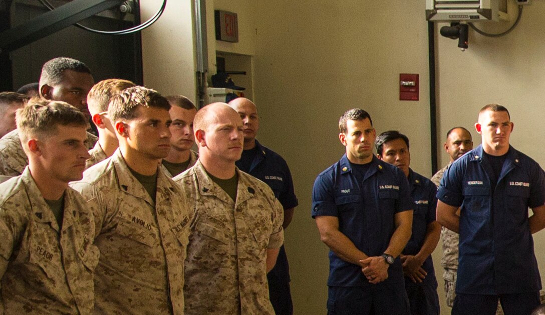 Marines, Sailors and U.S. Coastguardsmen with Special-Purpose Marine Air-Ground Task Force Africa 14 stand together during a visit from Lt. Gen. Robert Neller, the Commander of U.S. Marine Forces Europe aboard Naval Air Station Sigonella, Italy, Aug. 9, 2014. Marines with SP-MAGTF Afroca 14 have teamed with the U.S. Coast Guard for upcoming Theater Security Cooperation engagements in Africa.