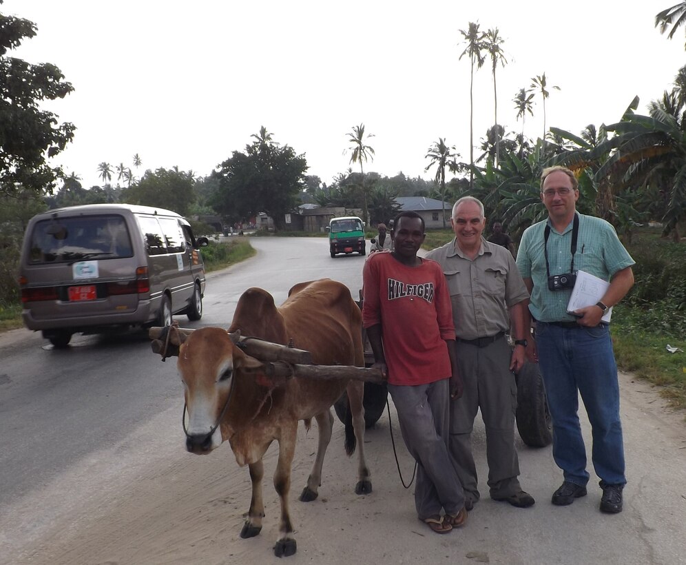 An oxen cart is one mode of transportation in Tanzania and one of the local drivers stops and takes a picture with Patrick Chauvey, chief of environmental programs, Fort Benning, Ga., and Danny Klima, civil engineer, Omaha District USACE. 