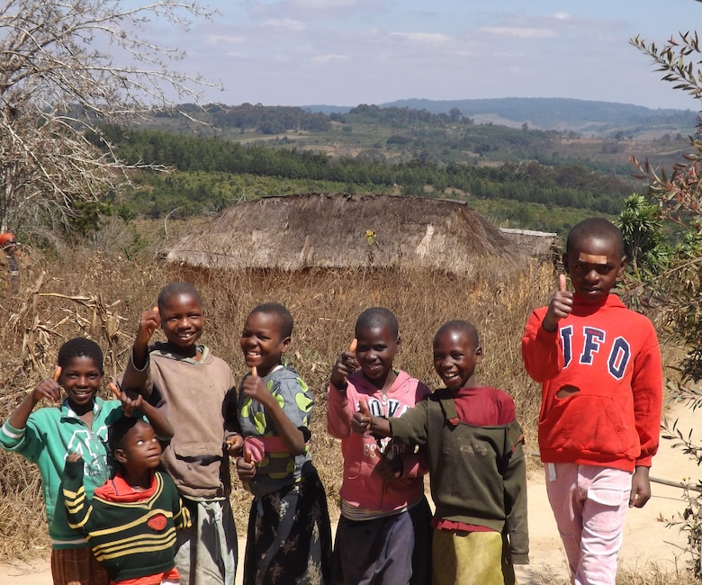 The local children of Tanzania give a thumbs up to the engineers from the United States who are in country assessing their roads for economic improvement. 