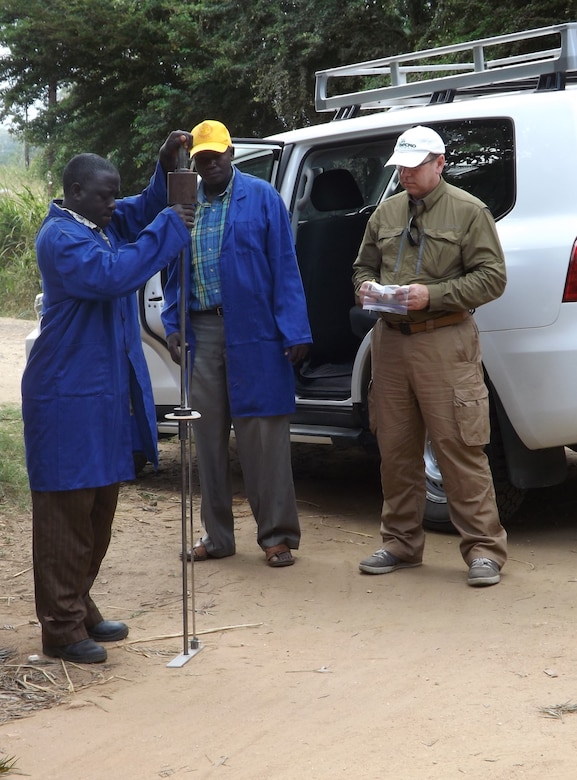 Gordon Lewis, geotechnical engineer, Omaha District USACE explains the measuring tool called a Dynamic Cone Penetrometer to TANROADS engineers in Tanzania as they assess the roads to provide a report back to the Millenium Challenge Corporation.