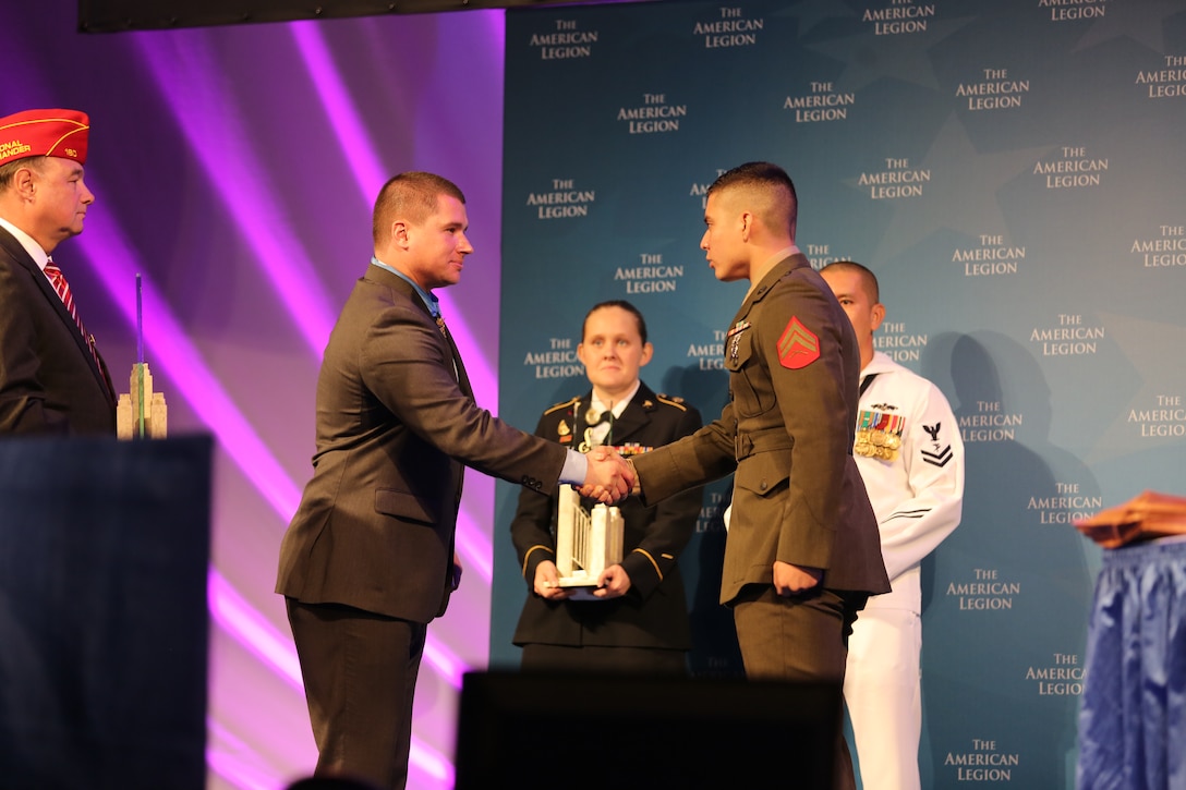 Army Sgt. Kyle White, Medal of Honor recipient, left, congratulates Cpl. Ricardo Gonzalez during the American Legion’s 96th National Convention in Charlotte, N.C., Aug. 26, 2014. Gonzalez was awarded the Spirit of Service Award for his exceptional contributions to his local community through volunteer efforts off-duty.  Gonzalez is a Marine Air-Ground Task Force planning specialist with 4th Marine Regiment at Camp Schwab, Okinawa, Japan.