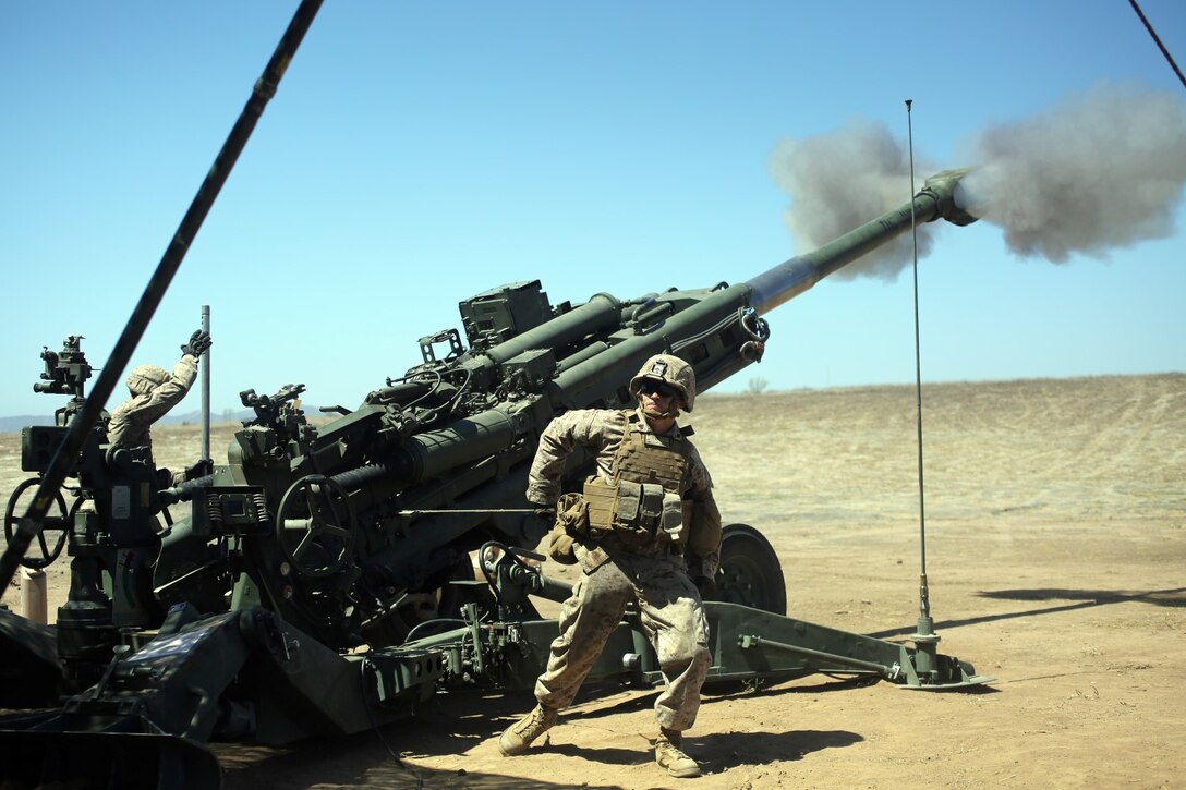 The gun crew of an artillery battery gives a demonstration of what occurs during a fire mission using an M777A2 lightweight howitzer to Marines and their spouses aboard Marine Corps Base Camp Pendleton, Calif., Sept. 6, 2014. Marines with 2nd Battalion, 11th Marine Regiment, held a Jane Wayne Day for Marine spouses to see what their service member does in the field. (U.S. Marine Corps photo by Lance Cpl. Tony Simmons/Released)