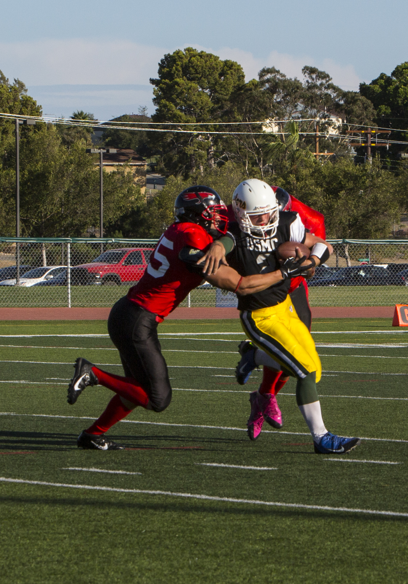 Players with the Marine Corps Air Station Miramar Falcons tackle a player with the 3rd Assault Amphibian Battalion Gators during a game at Paige Fieldhouse aboard Marine Corps Base Camp Pendleton, Calif., Sept. 9. The Falcons defeated the Gators 14-0.