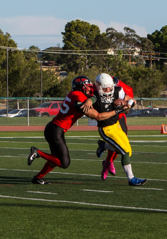 Players with the Marine Corps Air Station Miramar Falcons tackle a player with the 3rd Assault Amphibian Battalion Gators during a game at Paige Fieldhouse aboard Marine Corps Base Camp Pendleton, Calif., Sept. 9. The Falcons defeated the Gators 14-0.