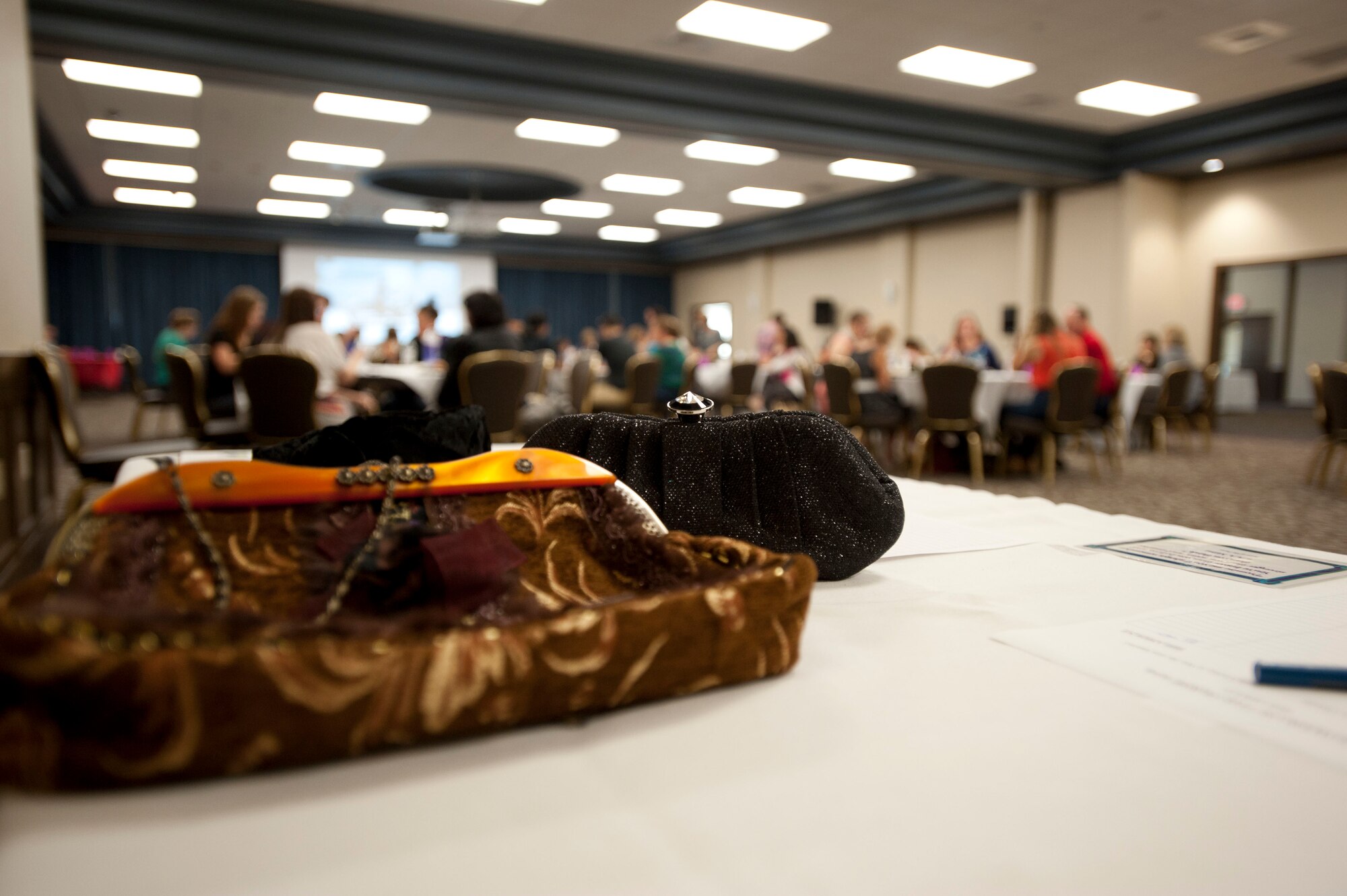 Members of Team Fairchild sit at the Power of the Purse luncheon Sept. 6, 2014, at Fairchild Air Force Base, Washington. The luncheon and silent action were put on by members of the 92nd Medical Group and Family Advocacy, and all proceeds were donated to benefit victims of domestic violence and to educate Fairchild AFB on child abuse, teen dating violence, and intimate partner violence.  (U.S. Air Force photo by Staff Sgt. Veronica Montes/Released) 
