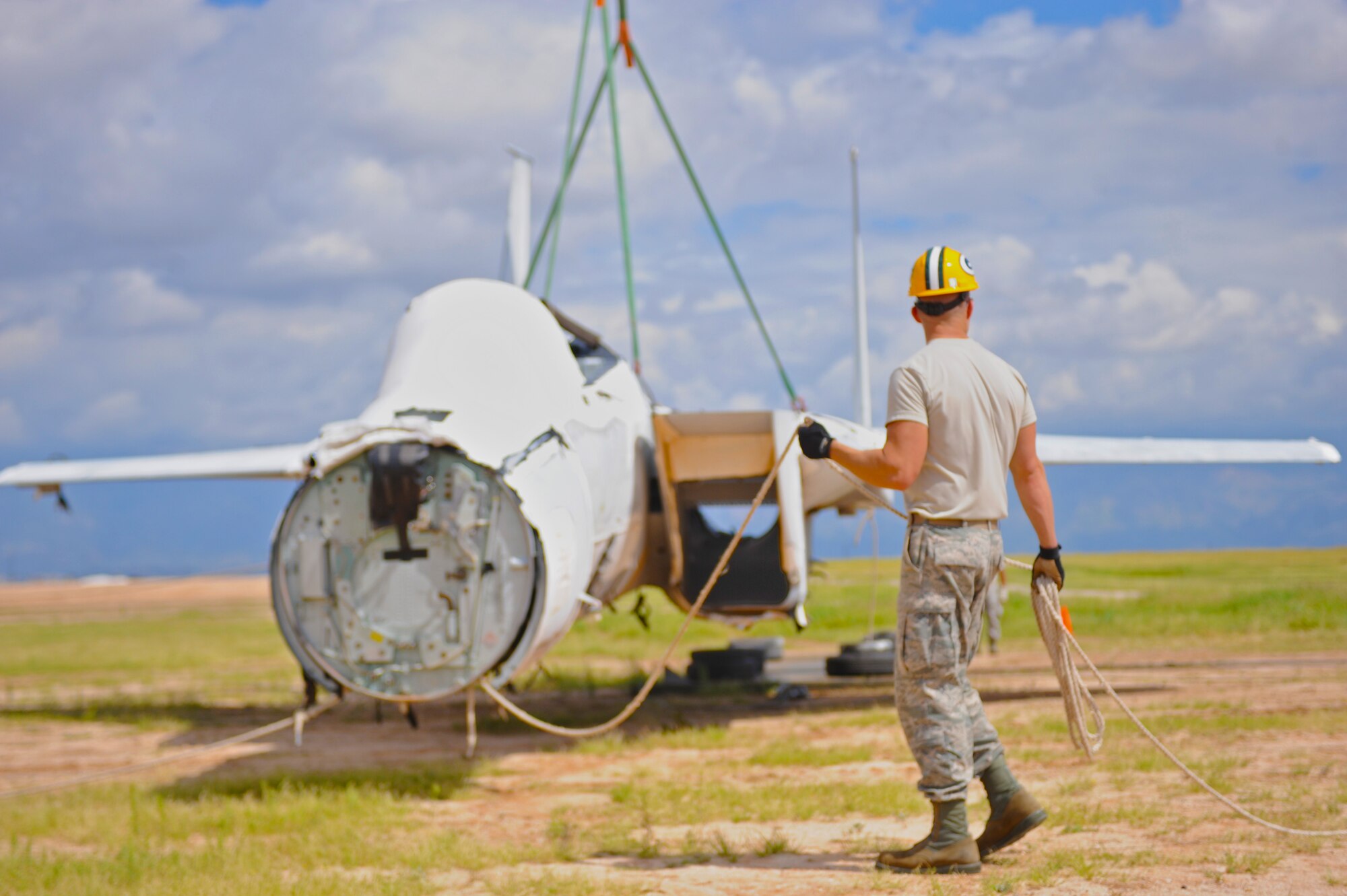 U.S. Air Force Reservist Tech. Sgt. Charles Coyne, 434th Maintenance Squadron metal technician, helps rotate a simulated crashed F-15 during Crash Damaged or Disabled Aircraft Recovery training at Davis-Monthan Air Force Base, Ariz., Sept. 9, 2014. In this exercise, the Airmen learn how to lift an F-15 onto a truck bed with a crane. (U.S. Air Force photo by Airman 1st Class Cheyenne Morigeau/ Released)