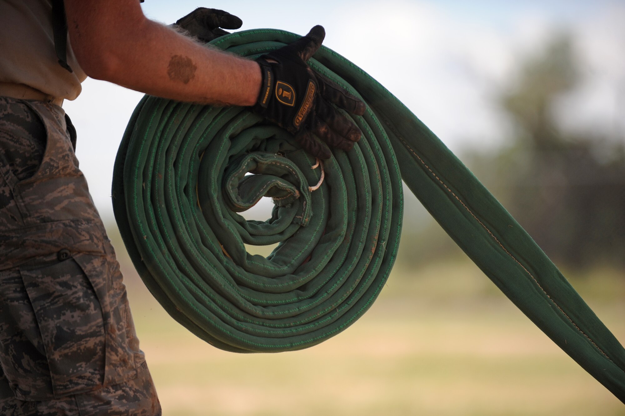 A cable used to debog a KC-135 Stratotanker is rolled up after a training scenario during Crash Damaged or Disabled Aircraft Recovery training at Davis-Monthan Air Force Base, Ariz., Sept. 9, 2014. During the training, Airmen were taught how to recover a KC-135 Str¬atotanker that was stuck in mud. (U.S. Air Force photo by Airman 1st Class Cheyenne Morigeau/Released)