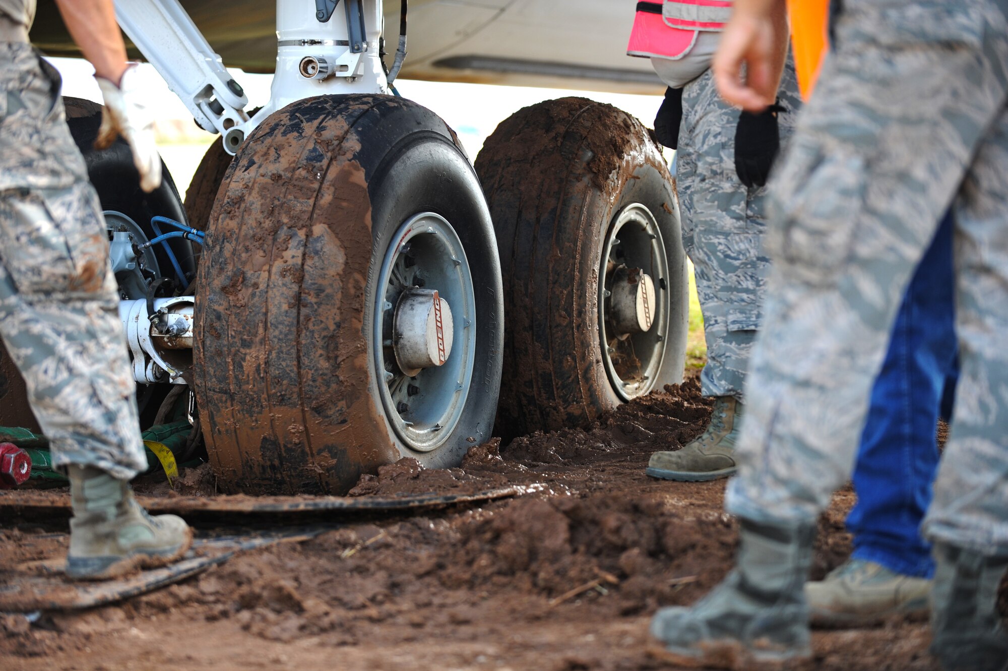 Airmen participating in Crash Damaged or Disabled Aircraft Recovery training determine how to debog the KC-135 Stratotanker at Davis-Monthan Air Force Base, Ariz., Sept. 9, 2014. Debogging is the action of pulling an aircraft that is stuck in mud back onto a hard surface. (U.S. Air Force photo by Airman 1st Class Cheyenne Morigeau/Released)