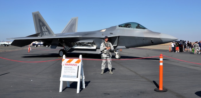 Senior Airman Ian Shorb, 9th Security Forces Squadron, safeguards a United States Air Force F-22 Raptor during the California Capital Airshow in Sacramento, Calif., Sept. 6, 2014. The Raptor is the world’s only fifth-generation fighter. (U.S. Air Force photo by Staff Sgt. Robert M. Trujillo/Released)