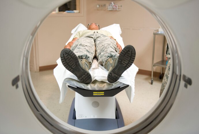 Airman 1st Class David Mathews, 99th Medical Surgical Operations Squadron diagnostic imaging phase two student , demonstrates the procedure for performing a CT scan at Mike O’ Callaghan Federal Medical Center on Nellis  Air Force Base, Nev., Aug. 26, 2014. A CT takes images of internal organs, bones, soft tissue and blood vessels, which provides greater detail than traditional X-rays. (U.S. Air Force photo by Airman 1st Class Mikaley Towle)