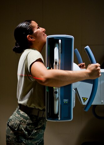 Airman 1st Class Cassandra Caballero, 99th Medical Surgical Operations Squadron diagnostic imaging phase two student, demonstrates correct form for receiving a chest X-ray at the Mike O’Callaghan Federal Medical Center, Nellis Air Force Base, Nev., Aug. 26, 2014. Airmen go through a 13-month, two-phase diagnostic imaging technical school to qualify to operate an X-ray machine. (U.S. Air Force photo by Airman 1st Class Thomas Spangler)
