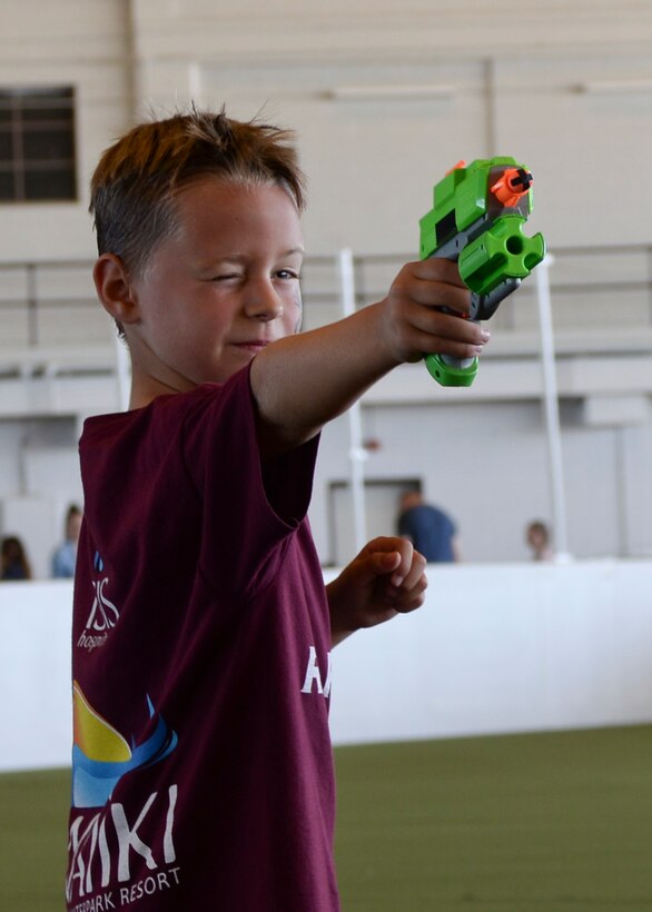 Landen Thompson, son of Staff Sgt. Kyle Thompson, 432nd Attack Squadron sensor operator, plays a game of quick draw during a Back to School Round-Up event inside the Pride Hangar at Ellsworth Air Force Base, S.D., Sept. 6, 2014. As part of the event, children played games and participated in activities with their families and friends to celebrate the start of the new school year. (U.S. Air Force photo by Senior Airman Anania Tekurio/Released) 