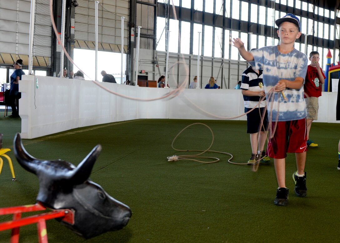 Dravin Cater, son of Tech. Sgt. Ellis Coley, 28th Logistics Readiness Squadron fuels laboratory NCO in charge, lasso’s a steer during a Back to School Round-Up event inside the Pride Hangar at Ellsworth Air Force Base, S.D., Sept. 6, 2014. The event featured more than 20 base and local organization information tables about youth programs, higher education and maintaining a healthy lifestyle while also providing activities for Airmen and their families to enjoy together. (U.S. Air Force photo by Senior Airman Anania Tekurio/Released)