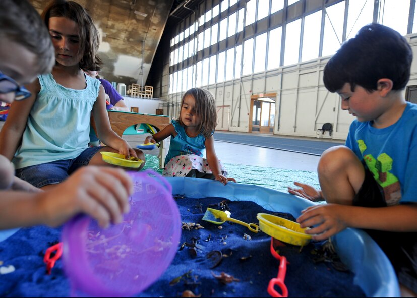 Children dig for treasure in a sandbox during a Back to School Round-Up event inside the Pride Hangar at Ellsworth Air Force Base, S.D., Sept. 6, 2014. In celebration of the start of the 2014 – 2015 school year, children were treated to activities ranging from digging for treasure to experiencing virtual outer space in the Journey Museum’s GeoDome. (U.S. Air Force photo by Senior Airman Anania Tekurio/Released)