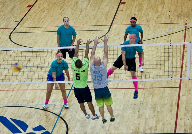 Teammates from the 823rd Maintenance Squadron work together to block a spiked volleyball during the intramural volleyball playoffs at the Warrior Fitness Center on Nellis Air Force Base, Nev., Sept. 9, 2014. The intense 30-minute game was tied until the last few minutes when the 99th Medical Group pulled together to score,winning the game 25 to 23. (U.S. Air Force photo by Airman 1st Class Rachel Loftis)