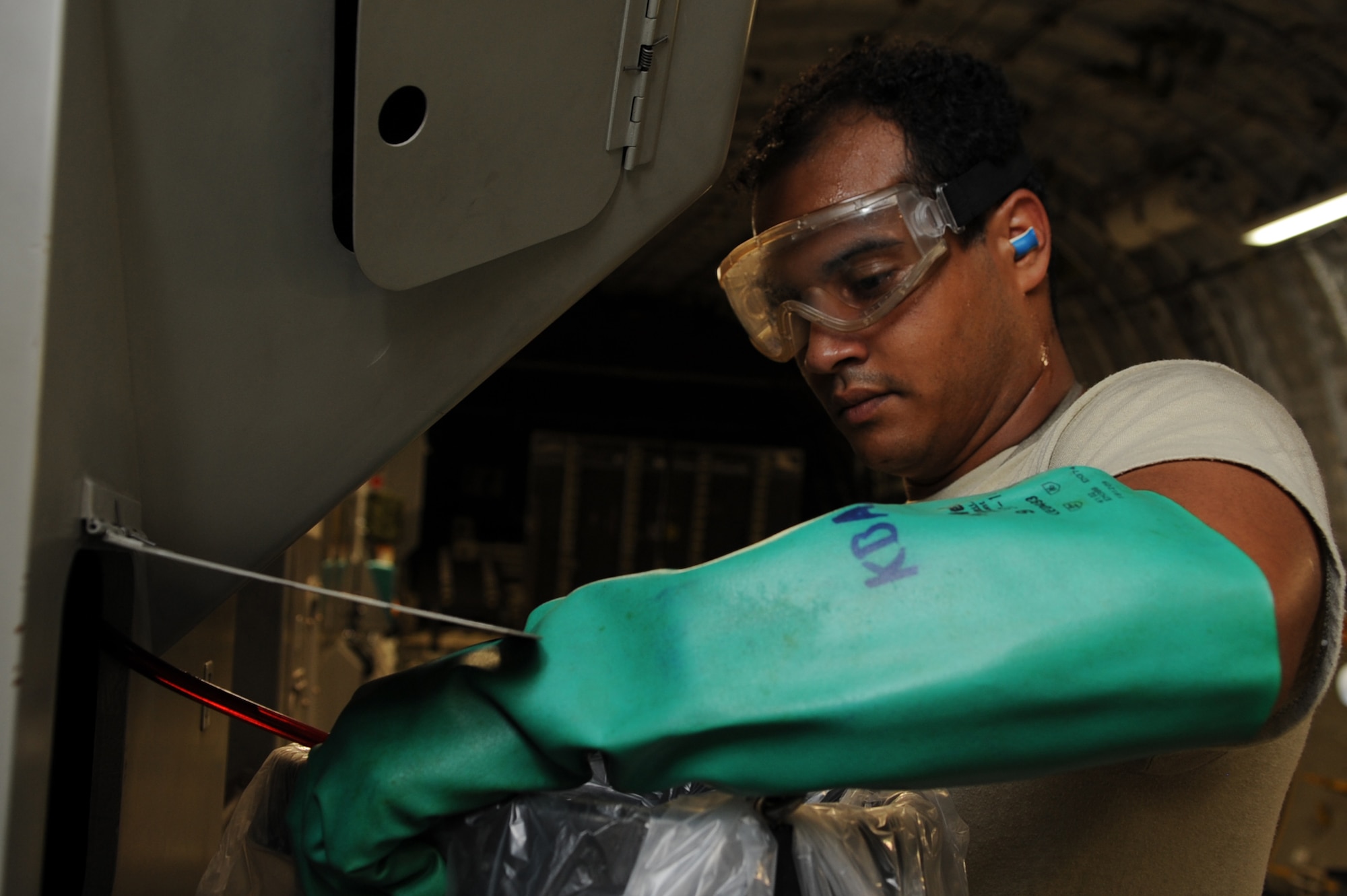 U.S. Air Force Staff Sgt. Cesar Rodriguez, 733rd Air Mobility Squadron electrical and environmental technician craftsman, drains hydraulic fluid from reserve on Kadena Air Base, Japan, Sept. 9, 2014. The 733rd AMS maintainers must be ready to work on many types of aircraft across varied specialties including engines, hydraulics, communications and navigation and electrical and environmental systems. (U.S. Air Force photo by Airman 1st Class Zackary A. Henry)