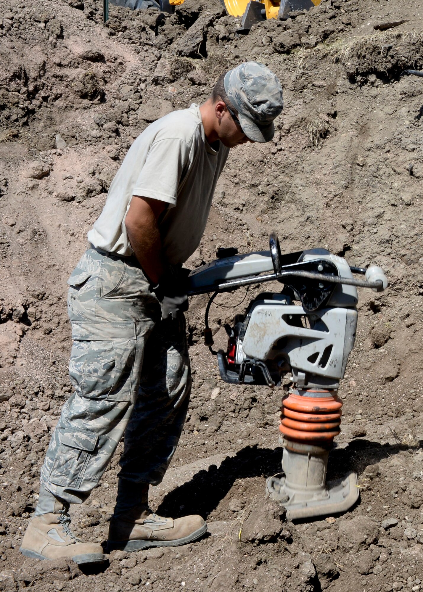 Senior Airman Chase Lyman, 28th Civil Engineer Squadron heavy equipment technician, uses a tamper machine during construction of a retaining wall outside the 28th Bomb Wing Headquarters building at Ellsworth Air Force Base, S.D., Sept. 8, 2014. The tamper is used to compact soil in order to provide a solid foundation for the wall. (U.S. Air Force photo by Senior Airman Anania Tekurio/Released)