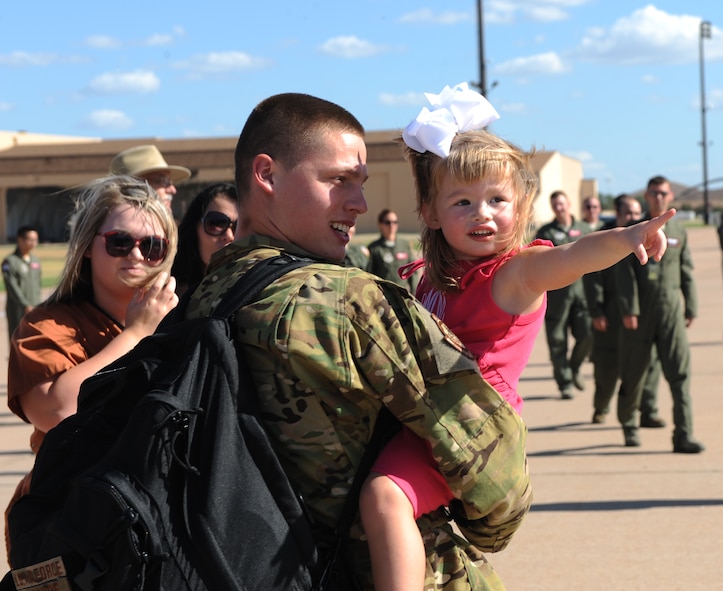U.S. Air Force Airman 1st Class Nicholas McGuire, 40th Airlift Squadron, holds his daughter Sept. 9, 2014, at Dyess Air Force Base, Texas. Airmen from the 317th Airlift Group were integrated with the 37th Airlift Squadron while deployed to Ramstein Air Base, Germany, in support of U.S. Africa Command operations.  (U.S. Air Force photo by Airman 1st Class Alexander Guerrero/Released)
