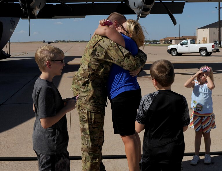 U.S. Air Force Master Sgt. Michael Dean, 39th Airlift Squadron, greets his family after returning from a deployment Sept. 9, 2014, at Dyess Air Force Base, Texas. During the deployment, Airmen from the 317th Airlift Group were tasked with providing support to from U.S. European Command to U.S. Africa Command operations. (U.S. Air Force photo by Airman 1st Class Alexander Guerrero/Released)