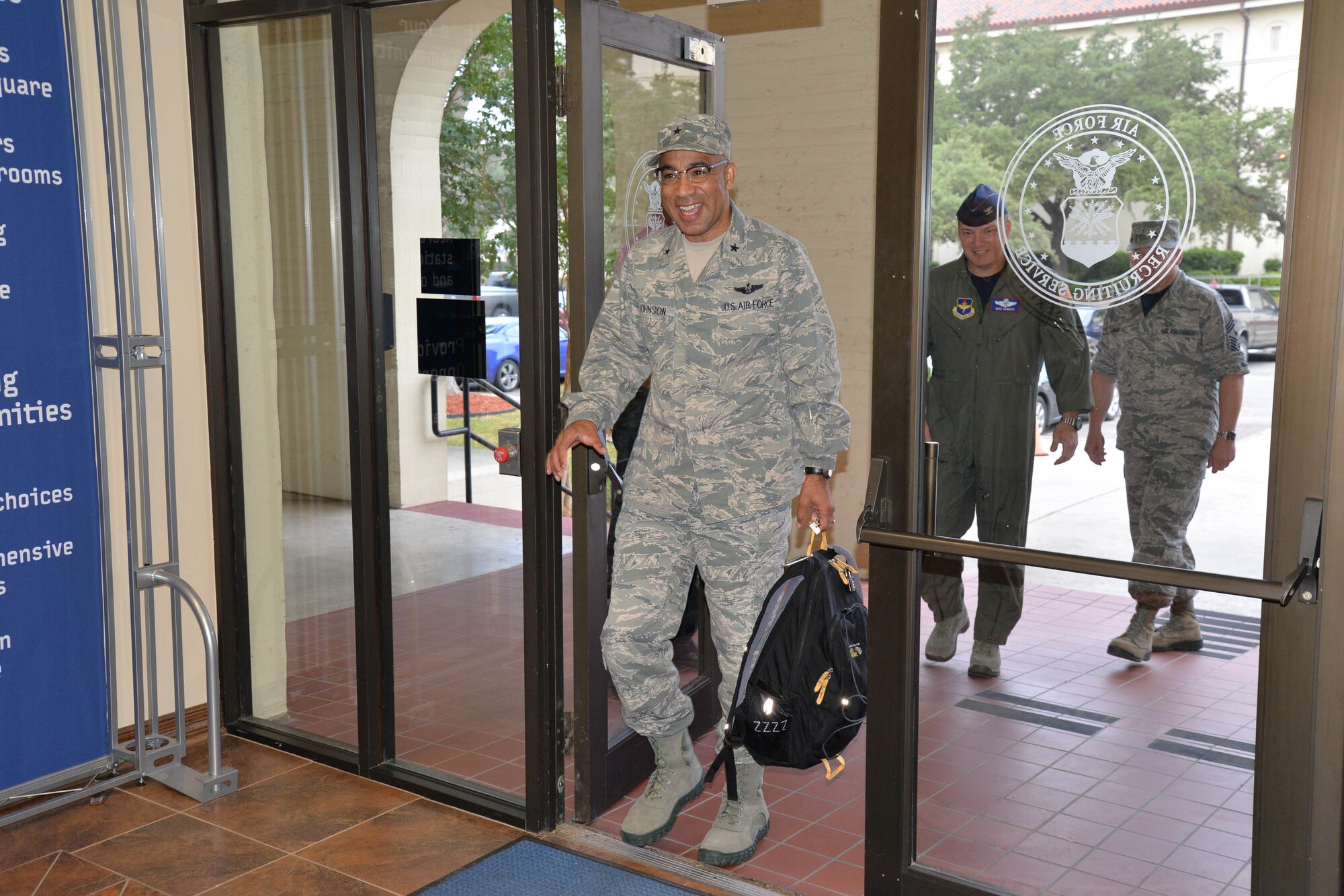 Brig. Gen. James C. Johnson enters the foyer of Air Force Recruiting Service Sept. 5, followed by Col. Michael Romero, AFRS vice commander, and Command Chief Master Sgt. Charles E. Lamer Jr. The general was greeted by the traditional recruiting cheer of “Boy, am I enthusiastic!” and said he was humbled by the experience. He assumes command of AFRS Sept. 11 in a ceremony at the Parr Club at Joint Base San Antonio-Randolph, Texas. For more photos, see Page 2. (U.S. Air Force photo/Annette Crawford)