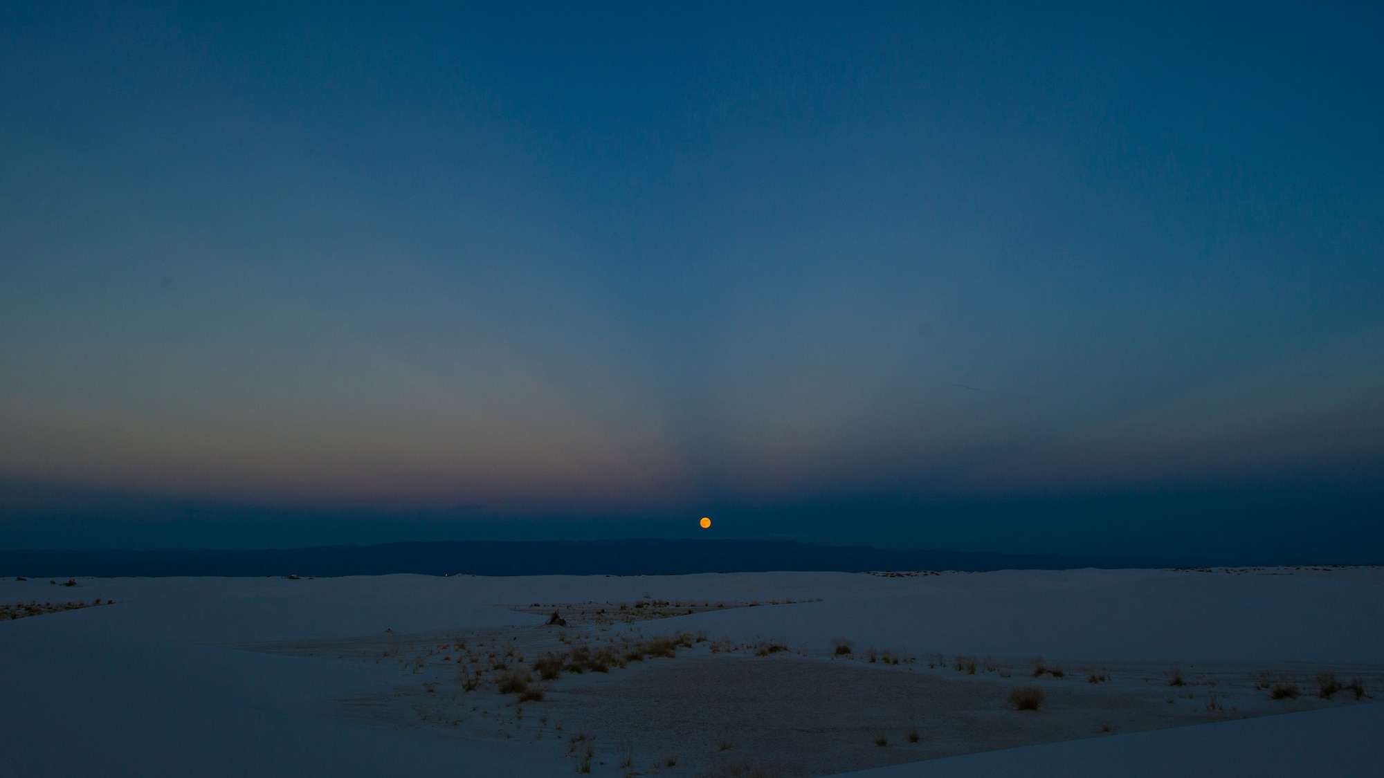 Shown is a full moon rising over White Sands National Monument, Sept. 8. White Sands National Monument hosts a monthly full moon night event where different guests and activities are planned for the guests to enjoy under a rising full moon. This month White Sands was host to Ernie Dogwolf Lovato, a musician, story teller and native New Mexican. (U.S. Air Force photo by Airman 1st Class Aaron Montoya / Released)