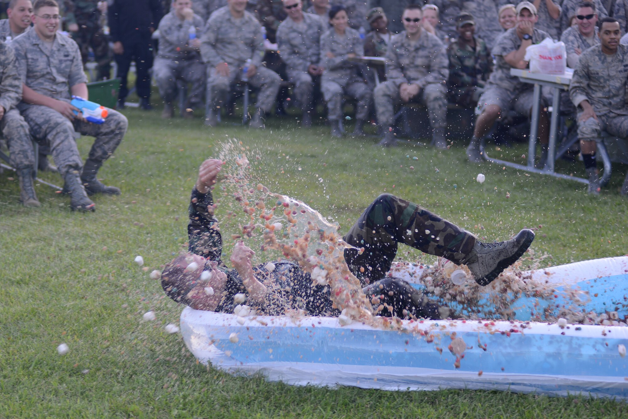 An Airman splashes through a "decontamination pool" during a combat dining-in at the Air National Guard 2014 Enlisted Leadership Symposium, Aug. 28, 2014, at Camp Dawson, W.V. The combat dining-in was a resiliency building event to cap off three days of professional development and leadership training for the Airmen. (U.S. Air National Guard photo by Senior Airman John E. Hillier)