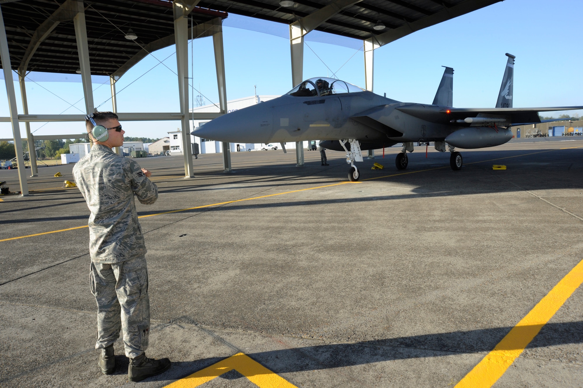 Senior Airman Adam Burger, assigned to the 142nd Fighter Wing Aircraft Maintenance Group, waits to marshal an F-15 Eagle to the flightline of the Portland Air National Guard Base, Ore., Sept. 4, 2014. (U.S. Air National Guard photo by Tech. Sgt. John Hughel, 142nd Fighter Wing Public Affairs/Released)
