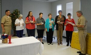 Capt. Timothy Sparks, Joint Base Charleston deputy commander and Naval Support Activity Charleston commanding officer (right), along with Cmdr. David Tarwater, NSA executive officer, conduct an installation ceremony for the newly elected officers of the  JB Charleston Navy Wives Club of America, Inc., Chapter MENRIV #240, Sept. 6, 2014, at Joint Base Charleston, S.C. The Club operates the Weapons Station Thrift Shop and provides numerous volunteer activities and support to active-duty service members and their families,  veterans and local community charities. Pictured (right to left) Sparks, Hazel Cole, president; Penney Carucci, vice president; Linda Hadden, recording secretary; Jan Hill, corresponding secretary; Fawn Hersman, treasurer and  Diane Glove, chaplain. (Courtesy photo)