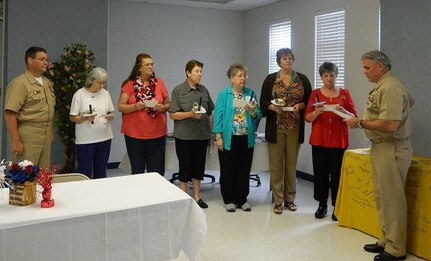 Capt. Timothy Sparks, Joint Base Charleston deputy commander and Naval Support Activity Charleston commanding officer (right), along with Cmdr. David Tarwater, NSA executive officer, conduct an installation ceremony for the newly elected officers of the  JB Charleston Navy Wives Club of America, Inc., Chapter MENRIV #240, Sept. 6, 2014, at Joint Base Charleston, S.C. The Club operates the Weapons Station Thrift Shop and provides numerous volunteer activities and support to active-duty service members and their families,  veterans and local community charities. Pictured (right to left) Sparks, Hazel Cole, president; Penney Carucci, vice president; Linda Hadden, recording secretary; Jan Hill, corresponding secretary; Fawn Hersman, treasurer and  Diane Glove, chaplain. (Courtesy photo)