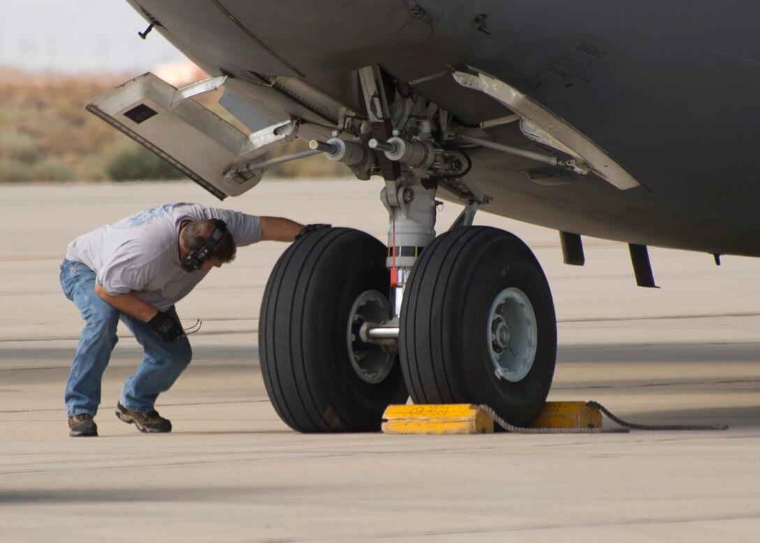 A 418th Flight Test Squadron crew chief inspects the C-17’s new Dunlop tires during a tire test August 20 on the Edwards flightline. Since August, the C-17 Global Reach Integrated Test Team at Edwards AFB has been putting the C-17’s new Dunlop tires through the rigors of testing to ensure the aircraft’s capability remains intact well into the future. (U.S. Air Force photo by Ethan Wagner)