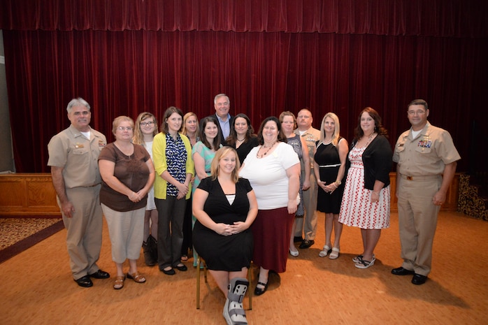 Retired Rear Admiral Robert Besal (back row center), Capt. TImothy Sparks, Joint Base Charleston deputy commander and Naval Support Activity commanding officer (left) and Cmdr. David Tarwater, NSA executive officer, congratulate LowCountry Ombudsmen during the Ombudsman Appreciation luncheon Sept. 10, 2014, at the Redbank Club on Joint Base Charleston, S.C. The Ombudsman in attendance included Jennifer Marsland, Naval Nuclear Power Training Command (seated), (left to right) Capt. Sparks; Donna Pappas, U.S. Coast Guard Cutter Gallatin; Brooke Johnson, Naval Operation Support Center Charleston; Missy Geiser, Naval Health Clinic Charleston; Sharon Schmelling, Naval Consolidated Brig Charleston; Chelsea Crowell, Naval Support Activity Charleston; Rear Adm. Besal; Aimee Pereira, NSA; Beth Darius, Naval Nuclear Power Training Unit; Sandy Barker, NNPTC; Master Chief Petty Officer Joe Gardner, NSA command master chief; Joy Leftwich, NNPTC; Kimberly Walker, NNPTC and Cmdr. Tarwater. Not in attendance were John Monroe, Space & Naval Warfare Systems Center Atlantic; Linda Stevens, Navy Munitions Command; Rachel Gentry, U.S. Coast Guard Sector Charleston and Stephanie Johnson, NHCC. Ombudsman are official representatives of the commanding officer and play a vital role in establishing and maintaining current and accurate communication between the command and its family members. The program was started in 1970 by Adm. E.R. Zumwalt, Jr., then Chief of Naval Operations, who issued one of his infamous Z-grams, Z-Gram 24 which is represented in the official Ombudsman Seal which contains 24 stars. Ombudsman Appreciation Day is actually Sept. 14, but commands celebrate the event at any time during the month of September. (U.S. Air Force photo/Eric Sesit)