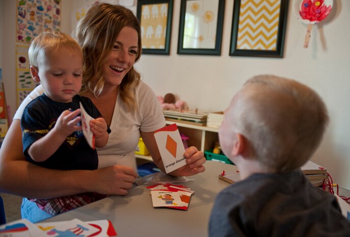 Brittany Morrill, a Family Child Care provider, shows memory cards to Sam and Ayden in her home on Nellis Air Force Base, Nev., Sept. 9, 2014. FCC providers are given free access to check out age-appropriate toys for the children in their care from the Lending Closet at the FCC office. (U.S. Air Force photo by Staff Sgt. Victoria Sneed)