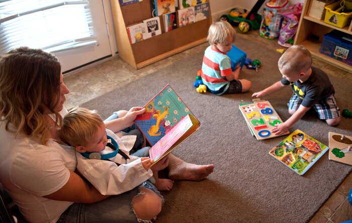 Brittany Morrill, a Family Child Care provider, reads to Kaiden as Tony and Ayden play in her home on Nellis Air Force Base, Nev., Sept. 9, 2014. FCC providers open their homes to military members unable to have their children placed in the Child Development Centers or School Age Program for a variety of reason, including alternate work schedules. (U.S. Air Force photo by Staff Sgt. Victoria Sneed)