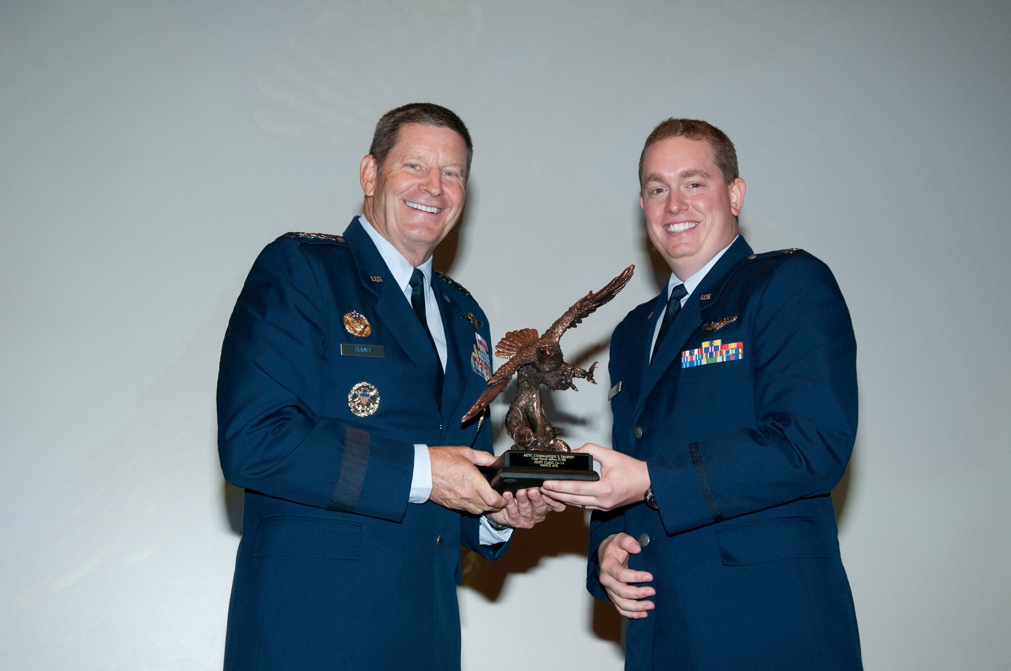 VANCE AIR FORCE BASE, Okla. -- Gen. Robin Rand, the Air Education & Training Command commander (left), presents the AETC Commander’s Trophy to Capt. David Jeffery, a member of Joint Specialized Undergraduate Pilot Training Class 14-14, during graduation Sept. 5 at the Base Auditorium. (U.S. Air Force photo/ Terry Wasson)