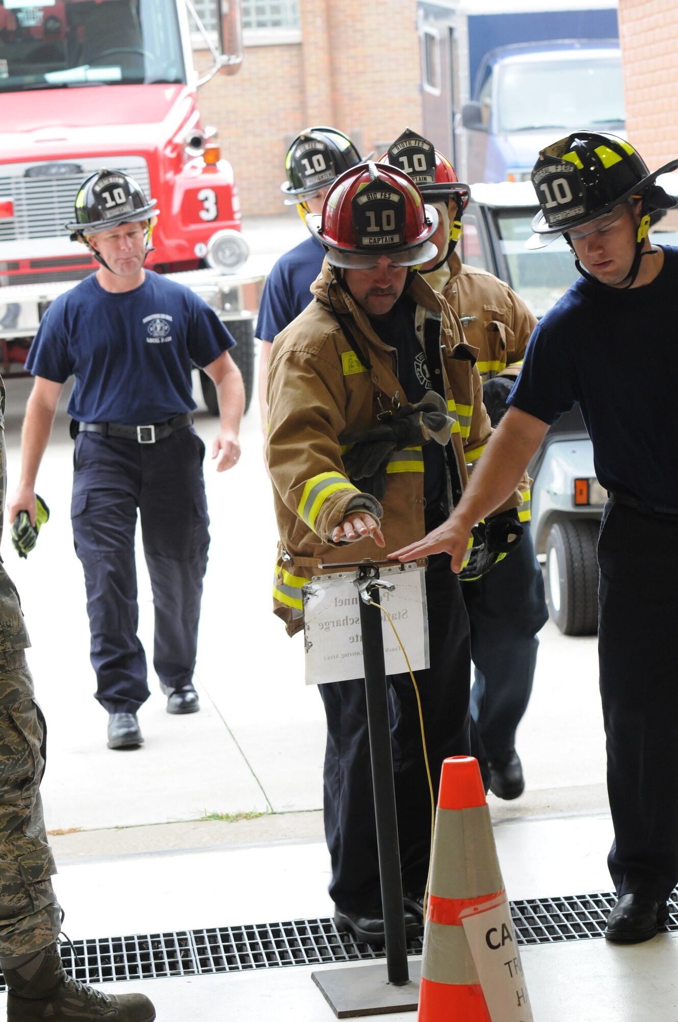 910th Civil Engineer Firefighters touch a static plate prior to entering hangar 302 for a confined space exercise. The static plate helps discharge static electricity to prevent fire hazards in areas with open fuel. The annual exercise took place here, Sept. 6, 2014. U.S. Air Force photo/Tech. Sgt. Rick Lisum.