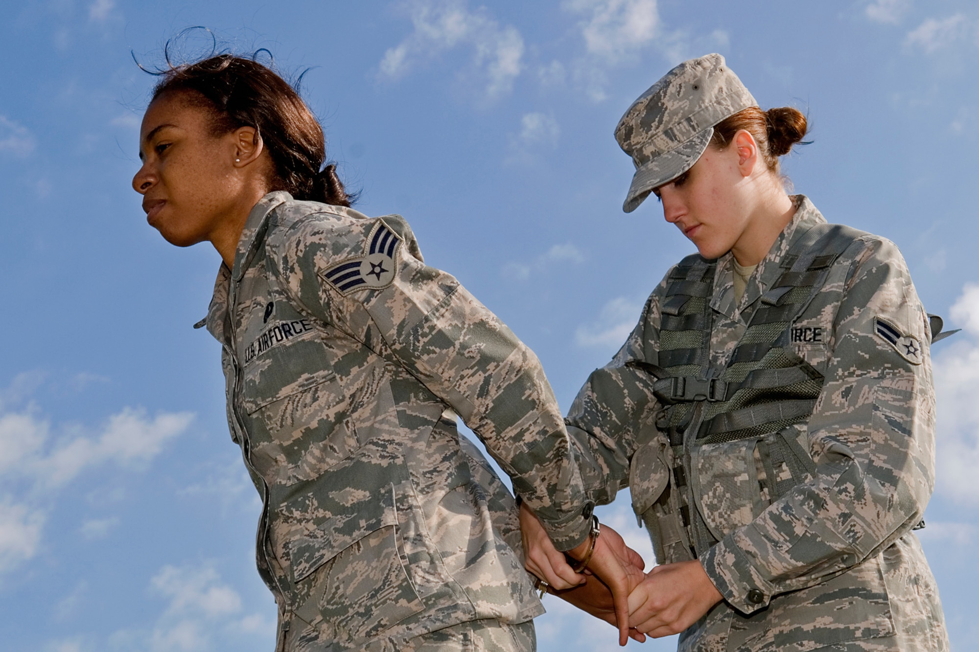 Senior Airman Jessica Murr, 434th Logistics Readiness Squadron fuels apprentice, handcuffs Senior Airman Caresia Barton, 434th LRS material management apprentice, during a security forces augmentee field-training exercise at Grissom Air Reserve Base, Aug. 11, 2014. Twenty-five Grissom Airmen participated in the week-long course to hone their combat training skills and help aid the 434th Security Forces Squadron during various missions. (U.S. Air Force photo/Staff Sgt. Ben Mota)

