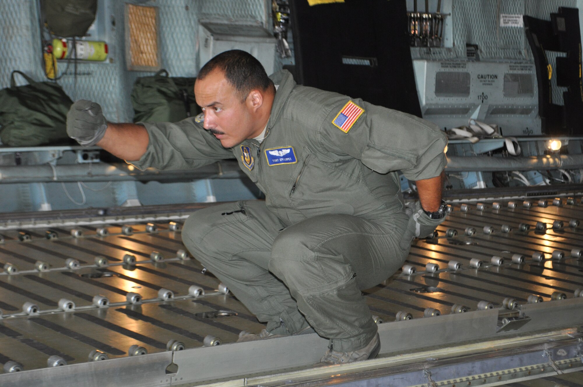 TRAVIS AIR FORCE BASE, Calif. -- With a clear eye and precision born of experience, Tech. Sgt. Epifanio Lopez guides a 60K loader up to the back of a C-5, during a 36-pallet load. Lopez is a reservist assigned to the 337th Airlift Squadron at Westover Air Reserve Base, Massachusetts. The loading was done alongside another C-5 from Joint Base San Antonio, also being fully loaded by active duty and reserve port dawgs training together at Travis AFB, California. (U.S. Air Force photo/Ellen Hatfield)